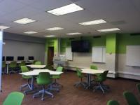 View of modular tables and front of classroom in 312 Denney Hall