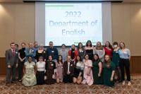 Several students gathered in front of a screen that reads 2022 Department of English