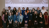 A group of people posing in front of a projection screen