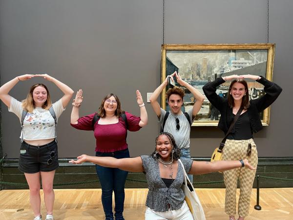 Four students spelling OHIO with their arms, one student below