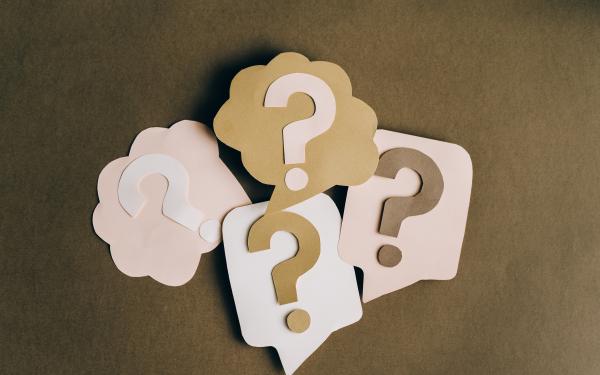 Four question marks on brown background