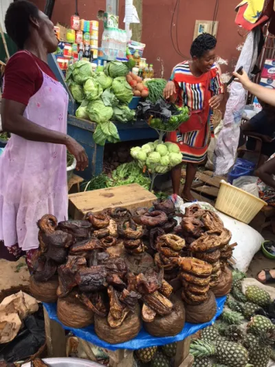 A vendor at the market in Ho, Ghana, admires her photo while selling vegetables, fruit, dry goods and smoked fish. 