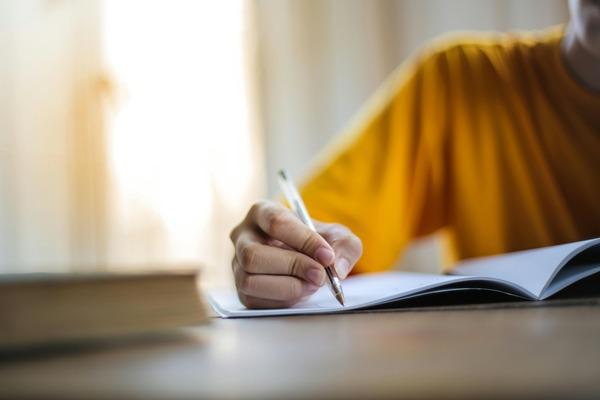 Person's hand writing in a notebook