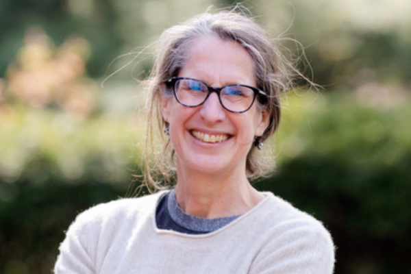 Elizabeth Hewitt smiling in front of some greenery.