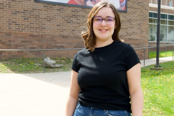 Sophia Wood standing in front of a brick building.