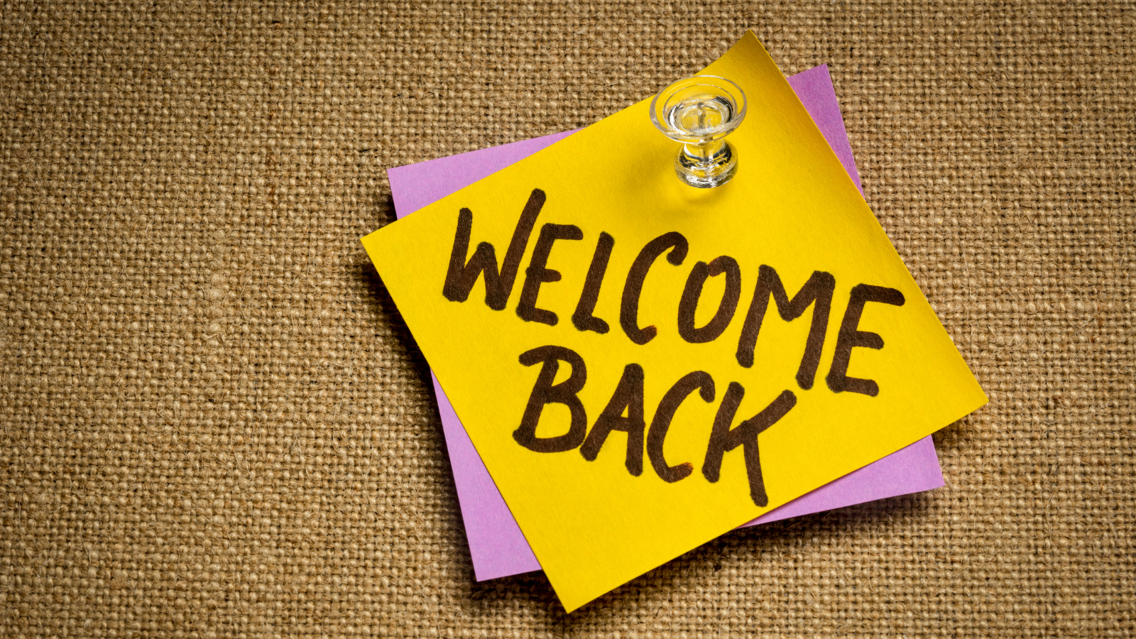 "Welcome back" handwritten on a post-it note