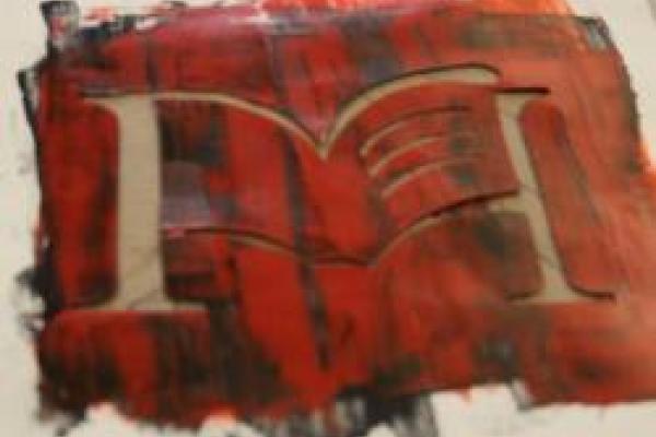 A screenprinting stencil of the letter M with a book superimposed on it, the stencil smeared with multicolored ink