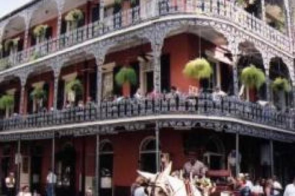 Multi-story building in New Orleans' French Quarter with ornate iron balcony railings
