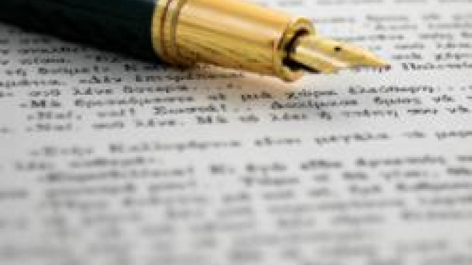 A gold-nibbed fountain pen resting on a page of printed text