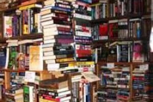 Stacked books in a very cluttered library