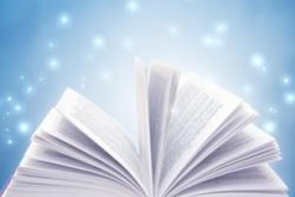 An open book with sparks of light floating out of it