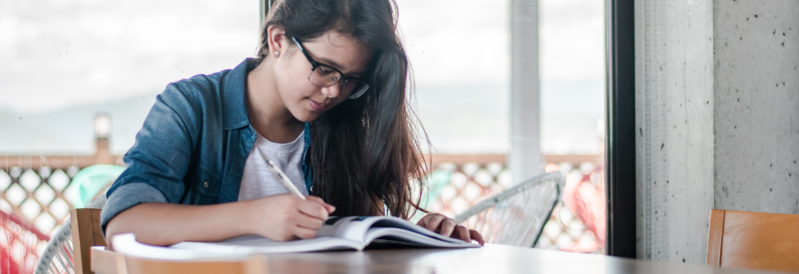 Student writing at a table