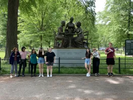 Students stand in front of New York monument to Women's Rights Pioneers